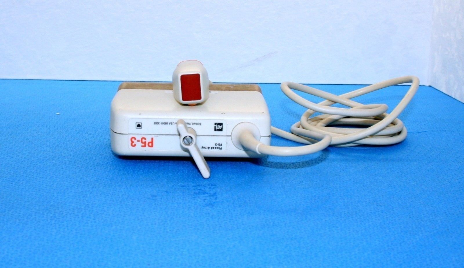a white probe sitting on top of a blue floor