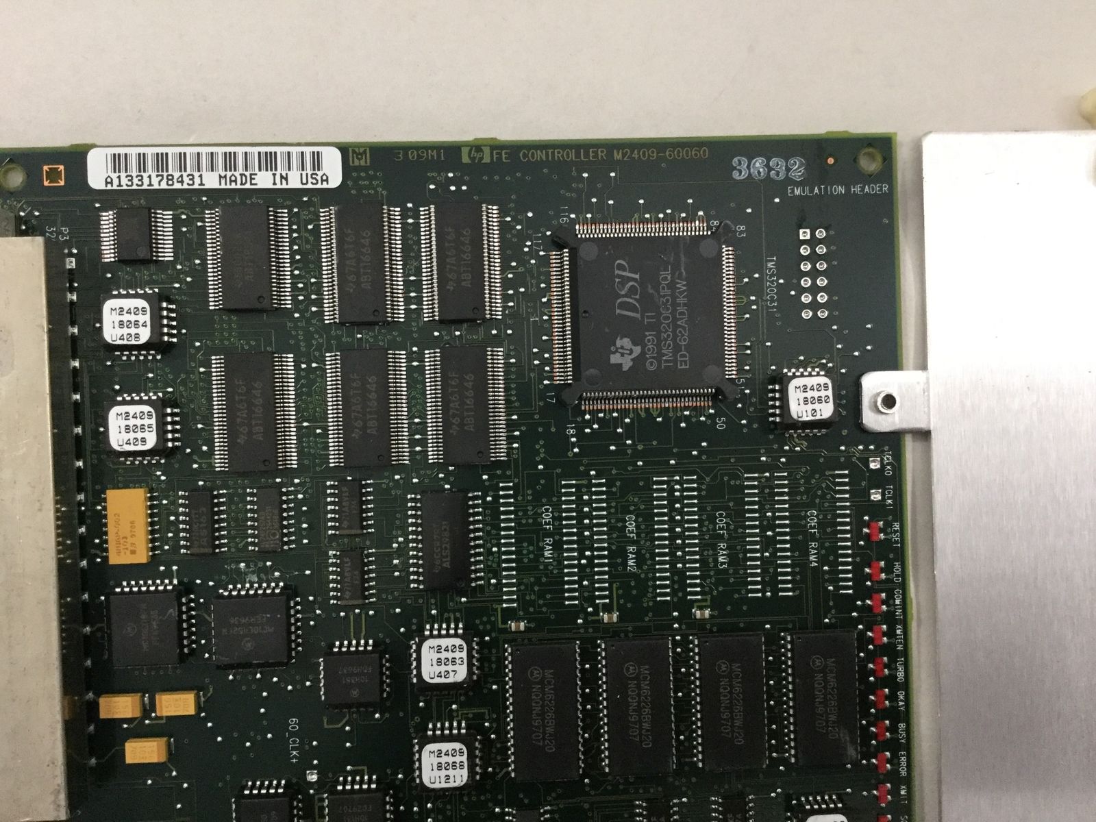 a close up of a computer board with a metal object in the background