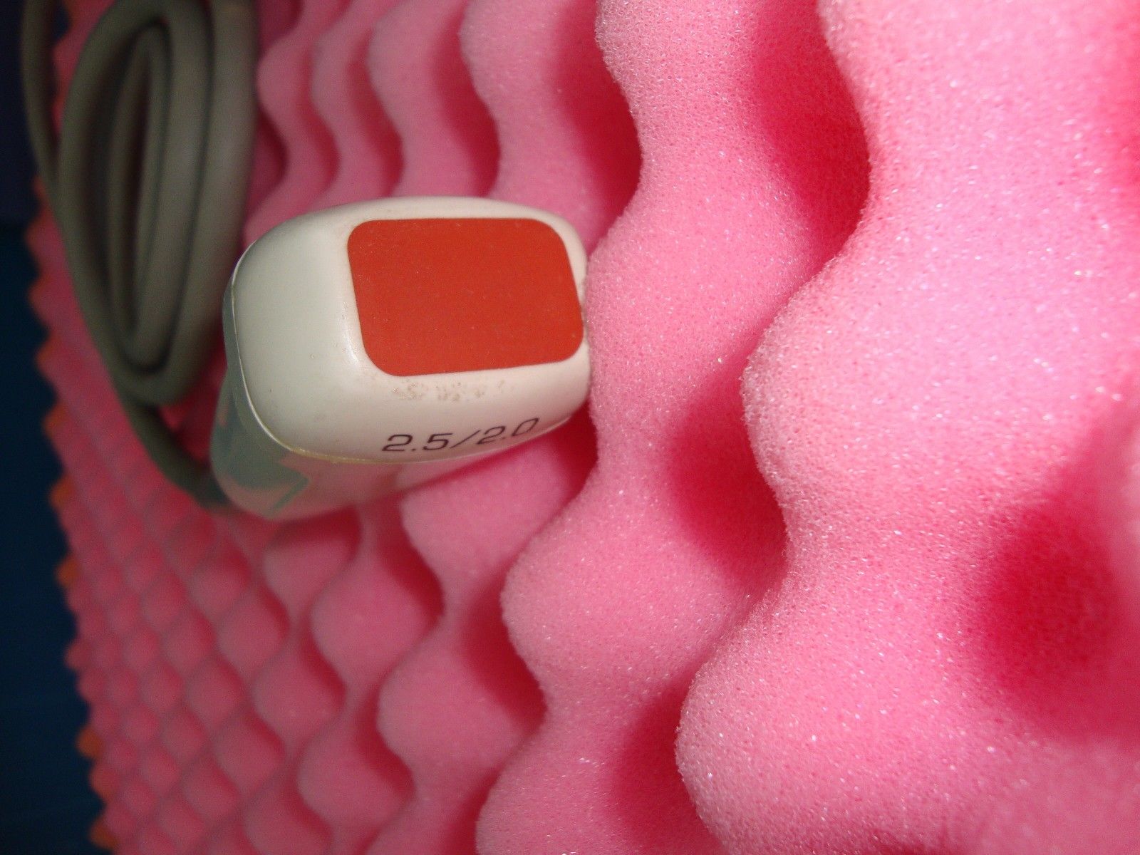 a close up of a red and white device on a pink surface
