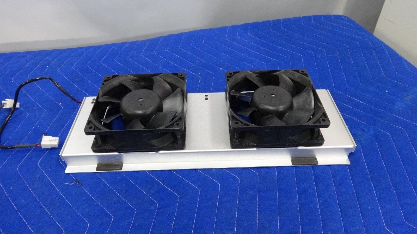 a couple of cooling fans sitting on top of a blue blanket