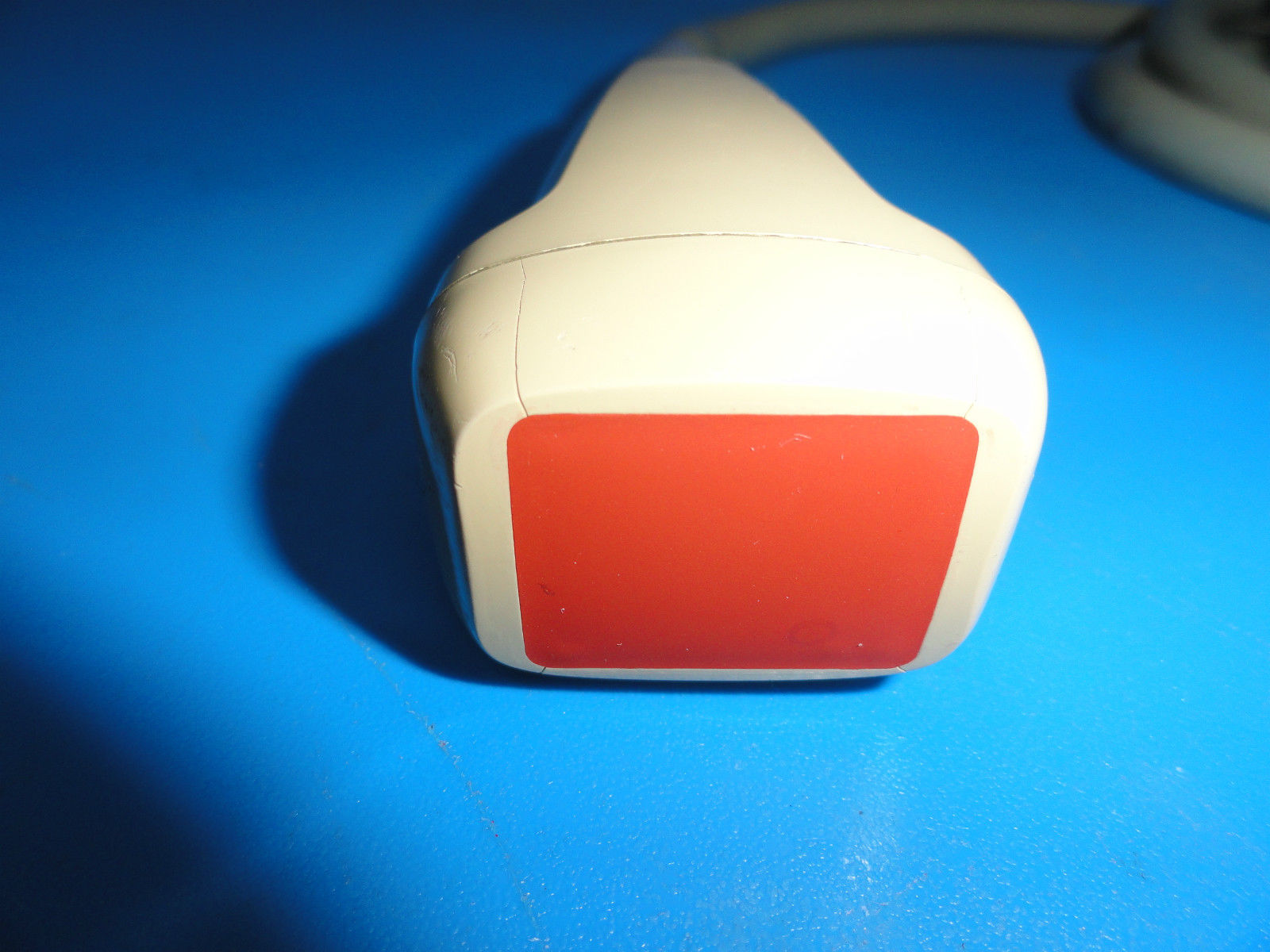 a close up of a red and white object on a blue surface