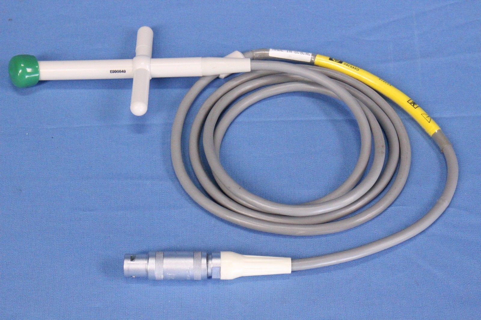 a white and yellow probe connected to a green and white device
