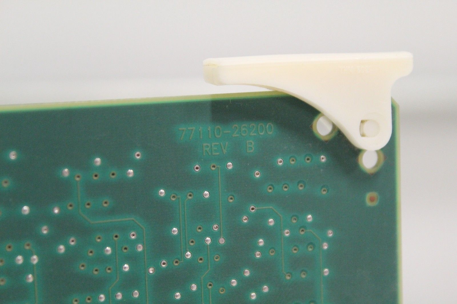 a close up of a green circuit board with white buttons