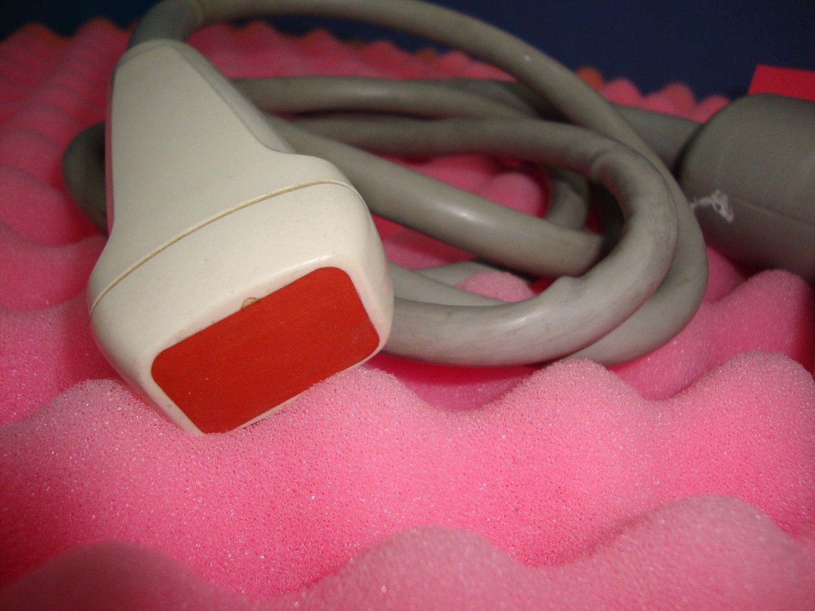 a close up of a probe head r on a pink surface